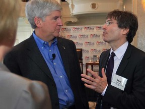 Gov. Rick Snyder, left,) speaks with Matt Marchand, president and CEO of the Windsor-Essex Regional Chamber of Commerce, at a town hall meeting Monday, Oct. 22, 2012,  in Detroit sponsored by the Canada United States Business Association. Snyder encouraged business leaders to support the Detroit River International Crossing project.