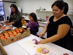 Wendy Sickles, left, children James and Kiara Mitchell and mom Joanne Mitchell, right, prepare healthy, homegrown vegetables for their Community Garden Harvest Social at St. Paul's Baptist Church on Pillette Avenue October 24, 2012. (NICK BRANCACCIO/The Windsor Star)