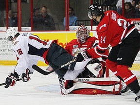 Windsor's Kerby Rychel, left, is checked by Owen Sound's Chris Bigras in front of goalie Brandon Hope at the WFCU Centre. (JASON KRYK/The Windsor Star)