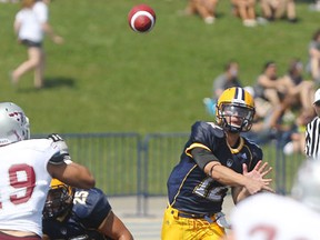 Lancers quarterback, Austin Kennedy, right, throws a pass against the Ottawa Gee-Gees at Alumni Field. (DAX MELMER/The Windsor Star)