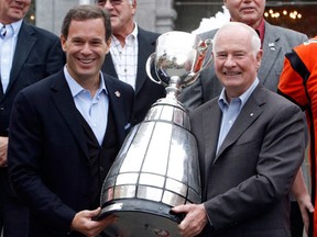 Governor General David Johnston, right, and CFL commissioner Mark Cohon hold the Grey Cup at Rideau Hall where the Cup was on display for public viewing in Ottawa, (THE CANADIAN PRESS/Fred Chartrand)