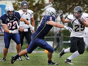 Windsor's Corey Bezaire, right, is tackled by London's Patrick Ramsay at Windsor Stadium. (DAX MELMER/The Windsor Star)