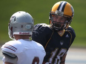 Lancers wide receiver Evan Pszczonak, right, has an exchange with Ottawa's Francois Rodrigue at Alumni Field. (DAX MELMER/The Windsor Star)