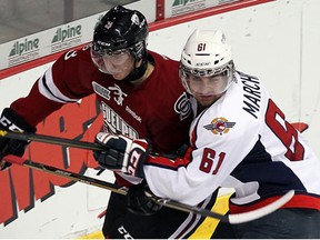 Spits forward Chris Marchese, right, checks Guelph's Andrey Pedan at the WFCU Centre. (TYLER BROWNBRIDGE/The Windsor Star)