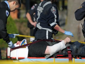 Paramedics tend to a man who was assaulted with a baseball bat in the 700 block of Brock Street in Windsor, Ont., Sunday, Oct. 21, 2012.  (DAX MELMER/The Windsor Star)