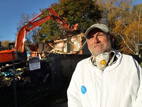 Joe Wenzler watches as a demolition crew tears down a home on Malden Road in LaSalle on October 16, 2012. The home is being torn down after being filled with cats for years.(TYLER BROWNBRIDGE / The Windsor Star)