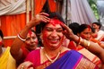 A Hindu woman reacts as others apply vermillion powder on her during Durga Puja festivities in New Delhi, India, Wednesday, Oct. 24, 2012. The festival commemorates the slaying of a demon king by lion-riding, ten armed goddess Durga, marking the triumph of good over evil. (AP Photo/Rajesh Kumar Singh