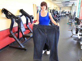 Natasha Foote displays the pants she wore when she weighed more than 400 lbs. She lost more than 200 lbs in 10 months after completely changing her lifestyle and developing a healthy diet and regular exercise routine.  (DAN JANISSE / The Windsor Star)