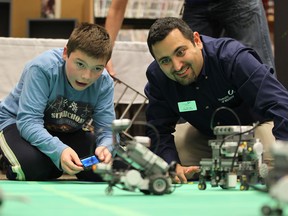From left, William Bechard, 11, and Ziad Kobti, Director of  the School of Computer Science at the University of Windsor, operate miniature robots during the first annual WE-Tech Alliance robotics open house held at the Windsor Public Library on October 11, 2012.   WE-Tech AllianceÕs program developer Irek Kusmierczyk, who organized the event, said more needs to be done to encourage young people to pursue education and careers in science, technology, engineering and math, because our economy demands it. (JASON KRYK/ The Windsor Star)