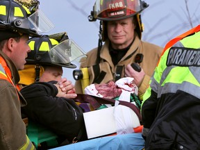 WINDSOR, ONT.:OCTOBER 27, 2012 -- Windsor firefighters and EMS paramedics tend to a man involved in a rollover on EC Row, west of Banwell Road, Saturday, Oct. 27, 2012.   (DAX MELMER/The Windsor Star)