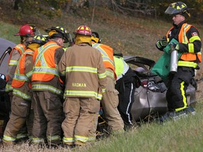 WINDSOR, ONT.:OCTOBER 27, 2012 -- Windsor firefighters and EMS paramedics tend to a man involved in a rollover on EC Row, west of Banwell Road, Saturday, Oct. 27, 2012.   (DAX MELMER/The Windsor Star)