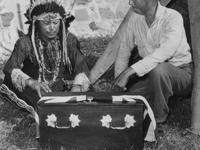 Aug.7/1941-Chief Samson Sands on the left, president of the Soldiers' Club and a former sergeant of the 149th Battalion of Lambton, and former Private Tom Isaas, right also of the 149th looking at the small casket draped with the Union Jack. (The Windsor Star-FILE)