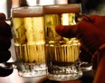 Two patrons at a pub toast their mugs of  beer in New York. (/Bloomberg News files)