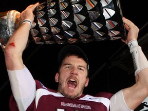 McMaster's quarterback Kyle Quinlan of South Woodslee lifts the Yates Cup trophy after beating the University of Guelph 30-13 Saturday in Hamilton. (THE CANADIAN PRESS/Dave Chidley)