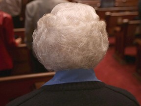 An elderly woman sitting in a church. (Getty Images files)