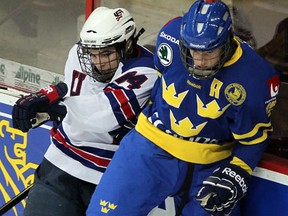 Spits draft pick Will Butcher, left, collides with Sweden's Jacob de la Rose at the World Under-17 Hockey Challenge at the WFCU Centre. (NICK BRANCACCIO/The Windsor Star)
