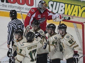 Spitfires goaltender Jaroslav Pavelka, back, looks down at the net as the London Knights celebrate a goal during the playoffs last year. (JASON KRYK/The Windsor Star)