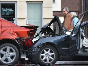 Pedestrians walk past a motor vehicle crash involving a Mercedes and a Dodge Avenger in the 1500 block of Ouellette Avenue in Windsor, Ont., Sunday, Nov. 25, 2012.  Minor injuries to three occupants of the Mercedes were reported.  The Avenger was parked and unoccupied at the time of the crash.   (DAX MELMER/The Windsor Star)