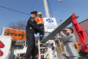 Windsor Police Chief Al Frederick, left,  and Neighbourhood Watch Windsor coordinator, Michael Lucier, with a neighbourhood watch sign during installation by City of Windsor workers on Hall Avenue in Windsor, Ontario.  See story by Trevor Wilhelm on new Neighbourhood Watch program.  (JASON KRYK/ The Windsor Star)