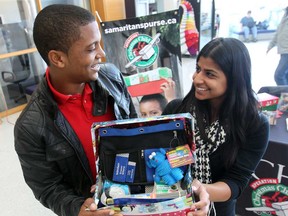 Jose Mareta, 23, from the Dominican Republic,  left, and Parveen Sehra , president of the Students Building Brighter Futures club, hold a shoebox filled with donated items during a press conference at the University of Windsor CAW Student Centre on November 8, 2012. (JASON KRYK/ The Windsor Star)