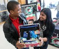 Jose Mareta, 23, from the Dominican Republic,  left, and Parveen Sehra , president of the Students Building Brighter Futures club, hold a shoebox filled with donated items during a press conference at the University of Windsor CAW Student Centre on November 8, 2012. (JASON KRYK/ The Windsor Star)