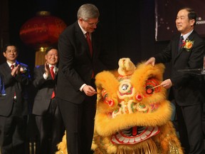 Canada's Prime Minister Stephen Harper, left, and Junsai Zhang ambassador to Canada of the People's Republic of China, paint the eye of a dragon dancer during the 6th Annual Chinese Business Excellence Award & New Year Celebration Gala Friday January 21, 2011 in Markham, Ont. (Brett Gundlock/National Post)