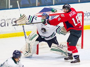 Spits forward Kerby Rychel, right, deflects a shot in front of Plymouth's Matt Mahalak Wednesday in Plymouth. (Rena Laverty/Plymouth Whalers)