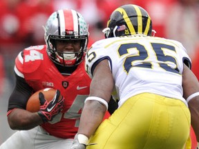 Ohio State's Carlos Hyde, left, is covered by Michigan's Kenny Demens in the second half at Ohio Stadium Saturday. Ohio State defeated Michigan 26-21. (Jamie Sabau/Getty Images)