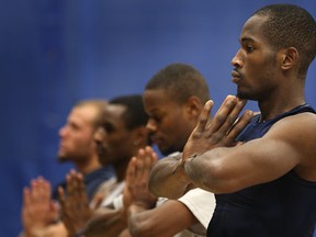 University of Windsor's Lien Phillip, right, and his teammates practise yoga at the St. Denis Centre. (DAN JANISSE/The Windsor Star)