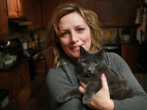 In this file photo, Jennifer Schiller holds the family's 3-year old cat, Gus Gus, at her home in Kingsville, Sunday, Nov. 4, 2012.  Gus Gus went missing in October of 2011 and due to a microchip implanted in his head was recently found in Northville, Michigan.  (DAX MELMER/The Windsor Star)