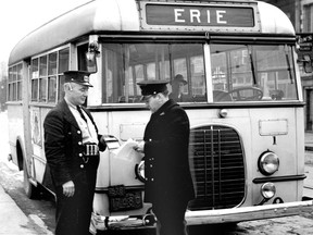 Scenes like this were enacted several times yesterday and today on the route of Erie buses as police took drivers names and addresses and warned them that they were violating the law by operating buses while an application for a court order to prevent bus operation on the line is pending. Operator Joseph Knapp who drove No.1 bus is seen showing his driver's licence to Constable Ed. "Spanky" MacFarlane. (The Windsor Star-FILE)