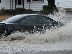 A car plows through a flooded Windsor street in this file photo. (TYLER BROWNBRIDGE / The Windsor Star)