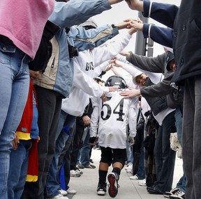 Tayvin Spina, 7. walks through a human tunnel from supporing parents after Spina's  tyke football team lost in the Windsor Minor Footbal Association championship game Sunday morning at Alumni Field in Windsor,  Ont. on Nov. 15, 2009.   The WMFA Tyke Giants lost to the Steelers 12-0.  (JASON KRYK/ THE WINDSOR STAR)