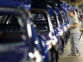 A Ford Motor Co. employee inspects 2012 Focus vehicles moving down the assembly line at the company's Michigan Assembly Plant in Wayne, Michigan, U.S., in this 2011 file photo. (Jeff Kowalsky/Bloomberg)