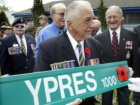 Second World War veteran Stan Scislowski, 81, formerly of the Perth Regiment of the Canadian Army, holds a new Ypres street sign designated with a poppy to remember the brave Canadian soldiers who paid the ultimate price. Scislowski himself was injured while carrying a wounded soldier from the battefields of Italy during the Second World War.  Windsor Mayor Eddie Francis and city councillors joined with veterans and current members of the Armed Forces during a brief ceremony on Ypres Avenue and Forest Avenue on May 11, 2005 The ceremony marked the official start to local VE Day celebrations and the public is invited to attend the Old Armoury on University Avenue East for a historical display.  (Windsor Star files)