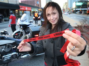 Officers with the Windsor Police Service, Lasalle Police and Ontario Provincial Police along with the local MADD chapter kicked off an awareness campaign Thursday, Nov. 1, 2012, in downtown Windsor, Ont. They were reminding people not to drink and drive. A ride check point was set up in Ouellette Ave. Nina Zajac of the MADD chapter displays a red ribbon during the event.   (DAN JANISSE/The Windsor Star)