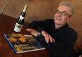 Gary May, author of Southern Exposure, poses with his book and an original Pelee Island icewine from 1983. (TYLER BROWNBRIDGE / The Windsor Star)