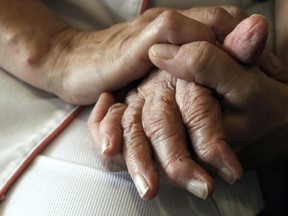 A nurse holding the hand of an elderly resident.