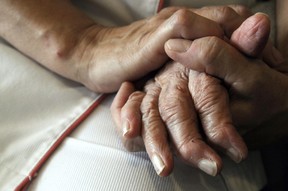 A nurse holding the hand of an elderly resident.