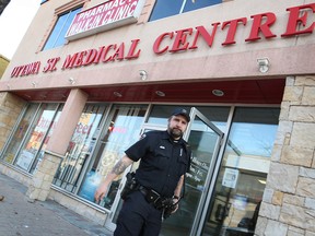 A Windsor police officer exits the medical centre and drugstore at 1535 Ottawa St. shortly after the establishment was robbed by a man with a pocket knife on Nov. 22, 2012. (Dan Janisse / The Windsor Star)