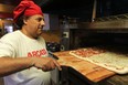 Bob Abumeeiz, owner of Arcata Pizzeria on Dougall Avenue, takes a pizza out of the oven in this 2011 file photo.  (DAX MELMER / The Windsor Star)