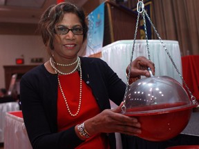 Kaysandra Curtis, president of the Rotary Club of Windsor (1918), donates money to kick-off the annual Christmas Kettle Campaign while at the 2012 Advisory Board Luncheon at the Caboto Club, Monday, Nov. 19, 2012.  (DAX MELMER/The Windsor Star)