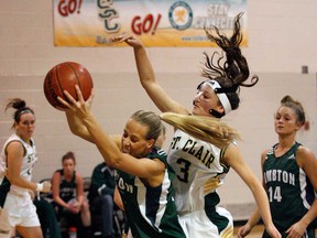 Lambton's Melanie Bouchard, left, grabs a rebound in front of St. Clair's Rachel Duic in OCAA women's basketball action at St. Clair College Wednesday Nov. 07, 2012. St. Clair's Deanna Dunn, back left, and Lambton's Riley Williams follow the play. (NICK BRANCACCIO/The Windsor Star)