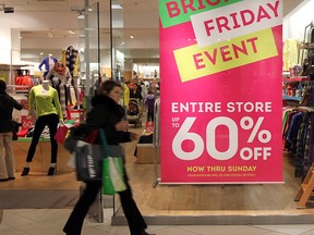 A shopper walks by a clothing store advertising Black Friday deals at the Devonshire Mall in Windsor, Ont. on Nov. 23, 2012. (Tyler Brownbridge / The Windsor Star)