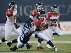 Windsor's Walter Spencer, centre, tackles Stampeders wide receiver Larry Taylor during third quarter CFL Grey Cup action Sunday November 25, 2012 in Toronto. (THE CANADIAN PRESS/Sean Kilpatrick)