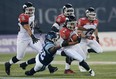 Windsor's Walter Spencer, centre, tackles Stampeders wide receiver Larry Taylor during third quarter CFL Grey Cup action Sunday November 25, 2012 in Toronto. (THE CANADIAN PRESS/Sean Kilpatrick)