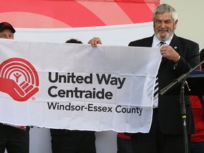 Windsor Mayor Eddie Francis (L) and Essex County Warden Tom Bain hold the United Way of Windsor-Essex County's flag during the 2011 campaign kickoff ceremony. (DAN JANISSE/The Windsor Star)
