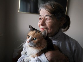 Lillian Scott, 73, holds onto Sunshine, 11, one of her three pet cats, in her apartment at 920 Ouellette Ave., Sunday, Dec. 16, 2012.  Scott is upset that two residents in her building were found have over a hundred dead cats in their freezers.  (DAX MELMER/The Windsor Star)