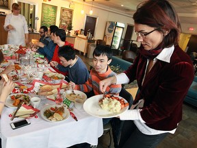 Volunteer Mariette Jones dishes out potatoes to students and other neighbourhood residents as they enjoy a free Christmas Day lunch at the Green Bean Cafe in Windsor on Tuesday, December 25, 2012. The cafe's employees and volunteers served a group of mostly international students a traditional Christmas dinner. (TYLER BROWNBRIDGE / The Windsor Star)