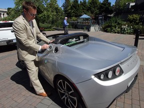 Vice-president business development Christopher Misch demonstrates how to charge the Tesla Roadster in July 2012 in Victori, B.C. (Postmedia News files)